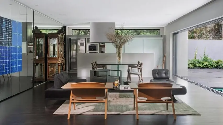 Sala com móveis de madeira cadeiras e cristaleira Projeto de Jayme Bernardo