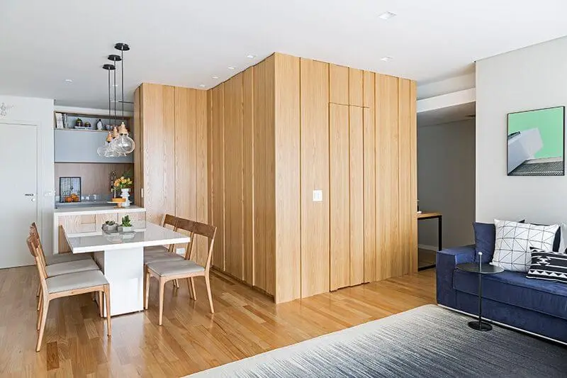 Sala com móveis de madeira paredes e cadeiras Projeto de Doob Arquitetura