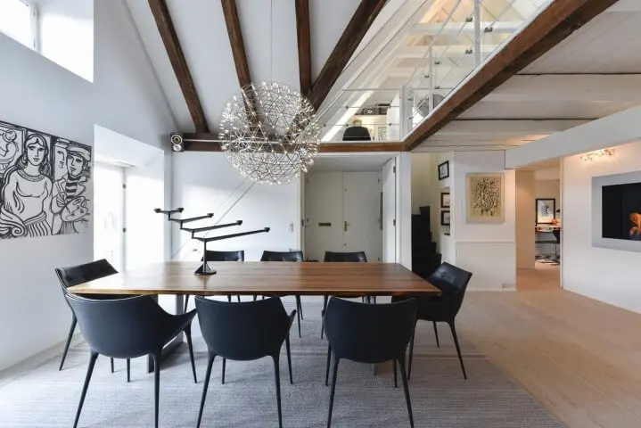 Sala de jantar ampla com móveis de madeira mesa e cadeiras pretas Projeto de Rodrigo Maia