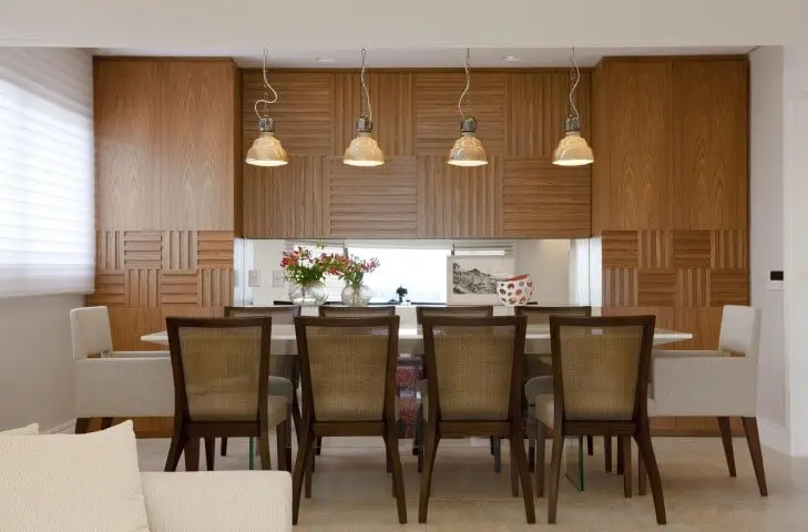 Sala de jantar com móveis de madeira e painel na parede Projeto de Marcelo Rosset