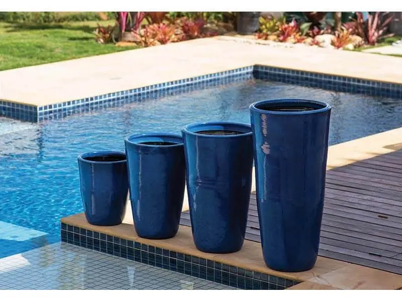 Vasos de cerâmica azuis na beira da piscina Foto de Terra Asia