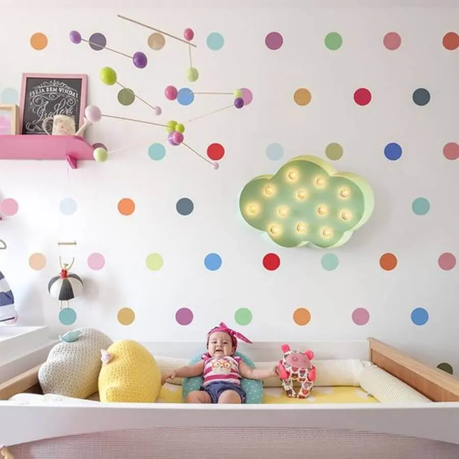 decoração colorida com papel de parede de bolinhas e enfeites para quarto de bebê com mobile colorido sobre o berço Foto Pinterest
