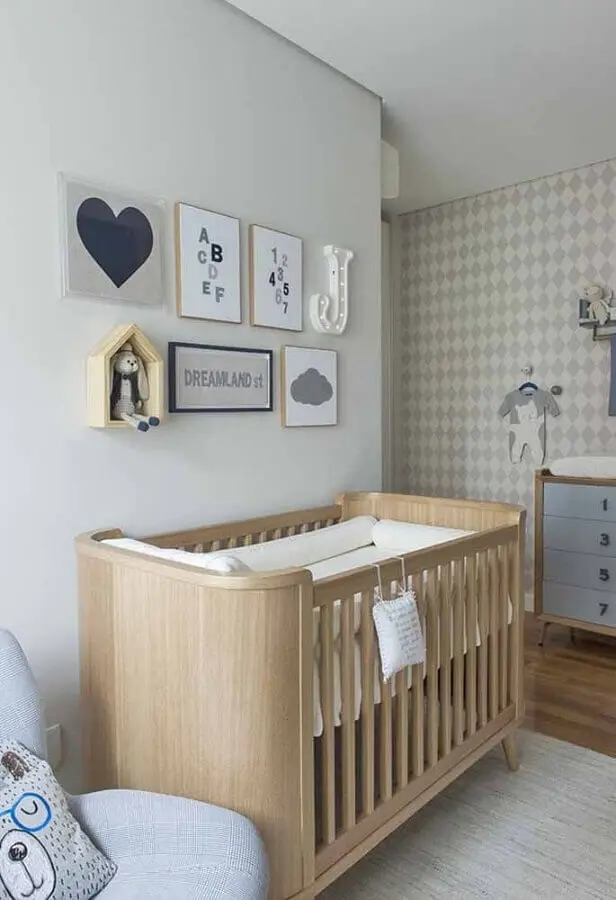decoração com quadros para quarto de bebê com papel de parede de losango cinza e berço de madeira Foto Decoralista