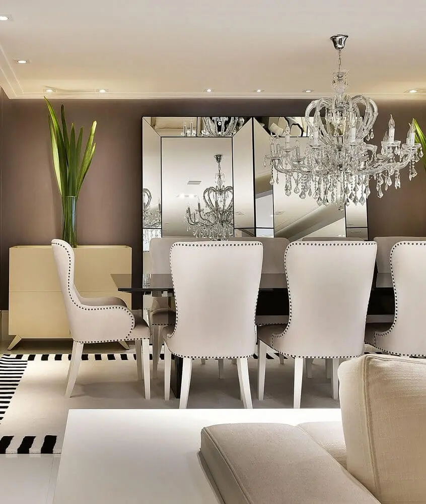 decoração elegante com lustre pendente para sala de jantar com espelho apoiado na parede e tapete preto e branco Foto Tetriz Arquitetura e Interiores