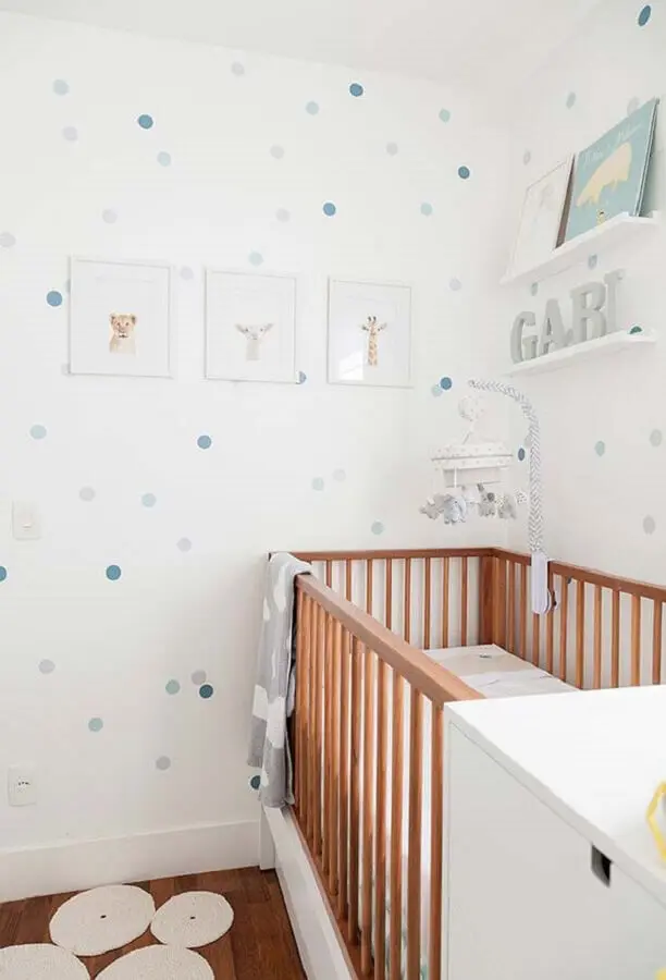 quadros para quarto de bebê todo branco com adesivos de bolinhas azuis na parede e berço de madeira Foto Uauá Baby