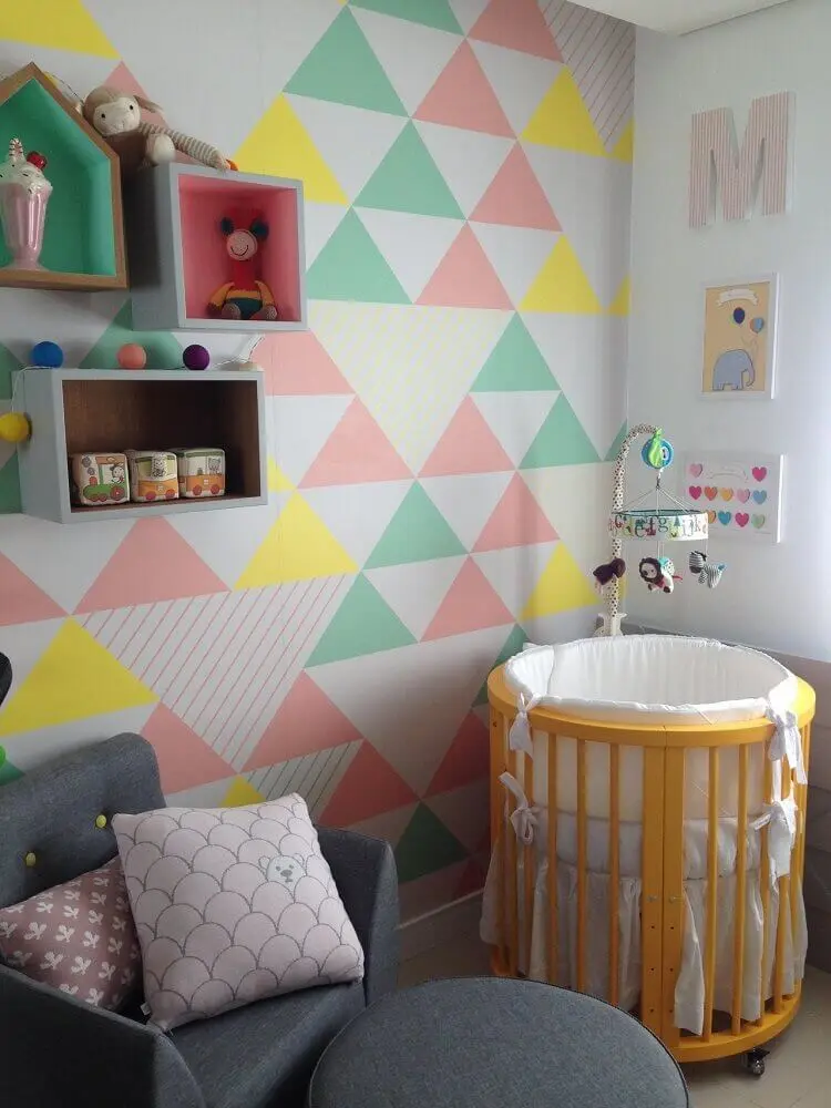 quarto de bebê moderno decorado com mini berço e papel de parede com triângulos coloridos Foto Maíra Schaeffer