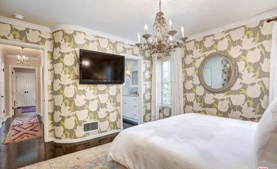 quarto melissa mccarthy decorado com lustre sobre a cama e papel de parede