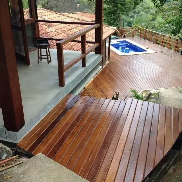 Área externa com piscina com piso de deck de madeira Projeto de Cals Arquitetos