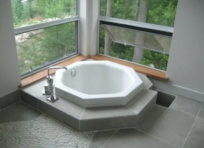 Banheira pequena com formato diferente em banheiro com chão de pedra Foto de Home Square