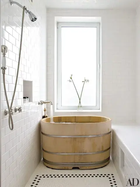 Banheira pequena de madeira próxima ao chuveiro Foto de Architectural Digest