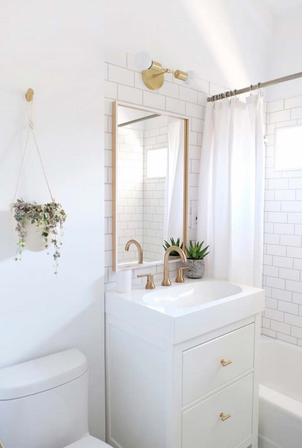 Banheiro pequeno decorado com detalhes em dourado