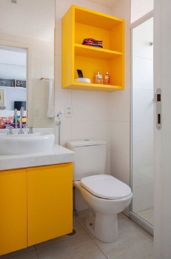Banheiro pequeno decorado com nichos em amarelo