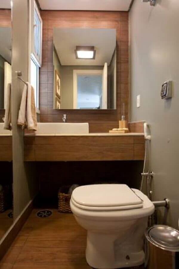 Banheiro pequeno decorado com revestimento em madeira