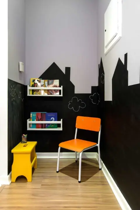 Clínica com cantinho infantil com parede chalkboard em formato de casinhas Projeto de Zark Studio