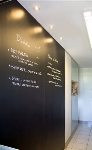 Cozinha compacta com painel chalkboard e luzes spot Projeto de Juliana de Sá