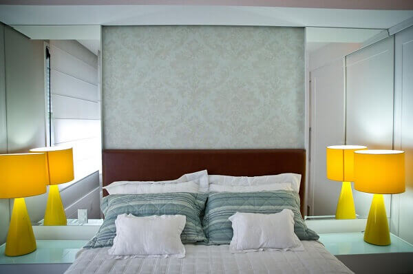 Marrom em cabeceira da cama e papel de parede claro