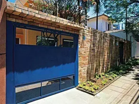 Portão de ferro azul com muro de tijolinhos Foto de Vai Com Tudo