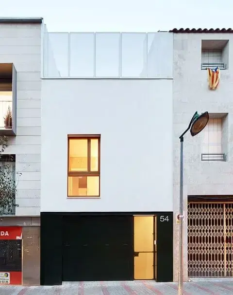Portão de ferro preto em casa com fachada branca minimalista Foto de Jose Hevia