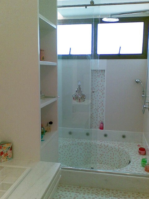 Sala de banho com banheira pequena revestida com pastilhas Projeto de Patricia Tavares