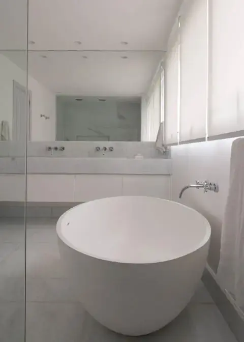 Sala de banho com decoração clean e banheira pequena branca Projeto de AMC Arquitetura