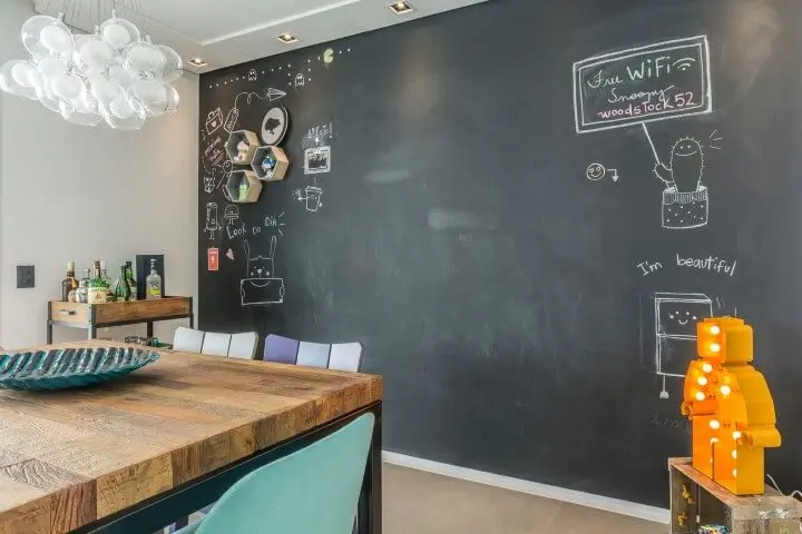 Sala de jantar com parede de chalkboard e nichos em formato de colméia Projeto de Idealizzare Arquitetura