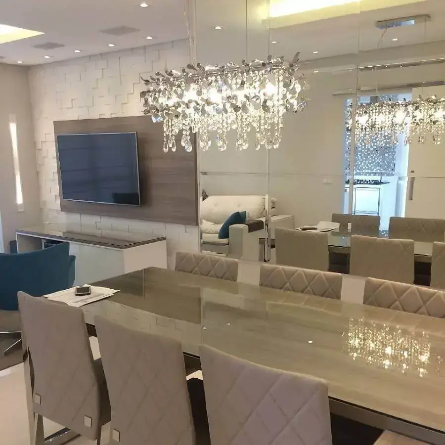decoração com parede espelhada e lustres de cristal para sala de jantar integrada com sala de estar Foto Mello e Condini Arquitetura