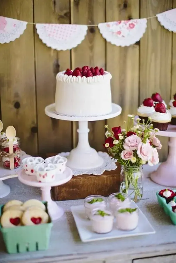 Simple red and white birthday decor with rustic panel and strawberry cake Photo Archzine