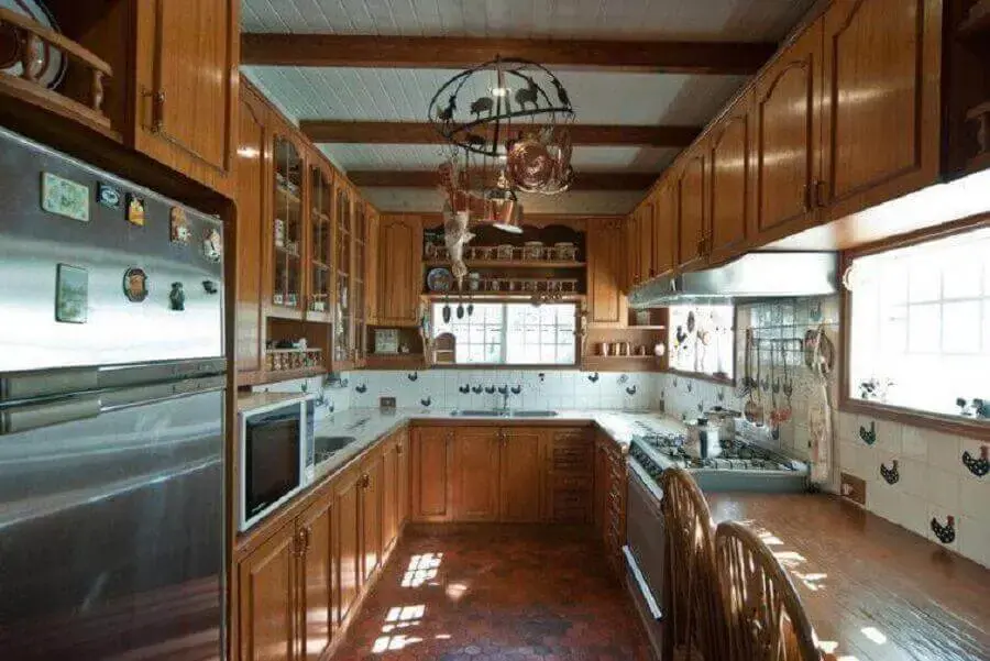 decoração de cozinha rústica corredor com armário planejado de madeira e azulejos com estampa de galinhas Foto Imovelweb