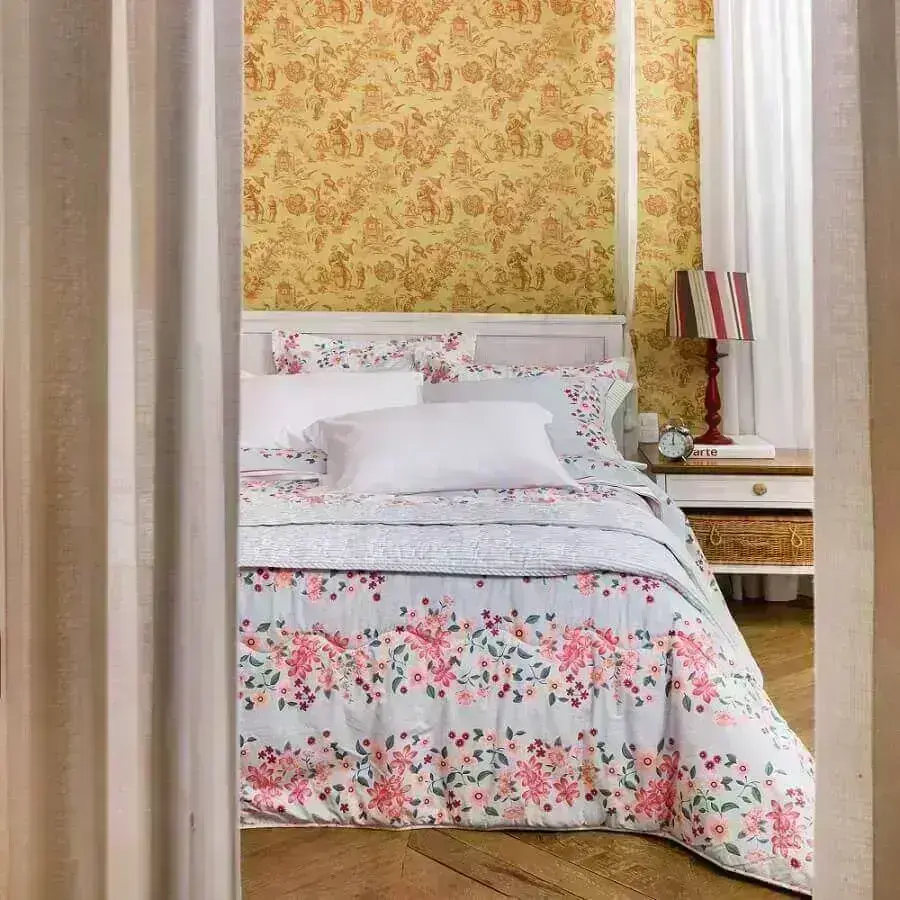 decoração de quarto com papel de parede e cama com várias camadas de enxoval
