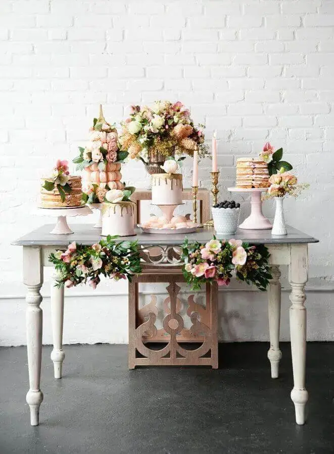 decoração para mesa de noivado simples e romântico em tons de rosa com vários arranjos de flores Foto Pesona Pengantin