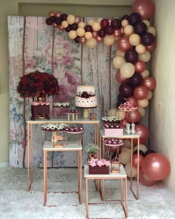 decoração simples de noivado com bolo dois andares e arranjo com balões Foto Del Bosque Decorações Locações