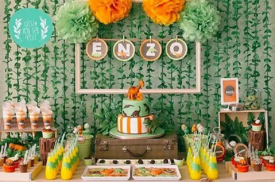 dinosaur theme for boy birthday decor with foliage panel and two-tiered cake Photo Pinterest