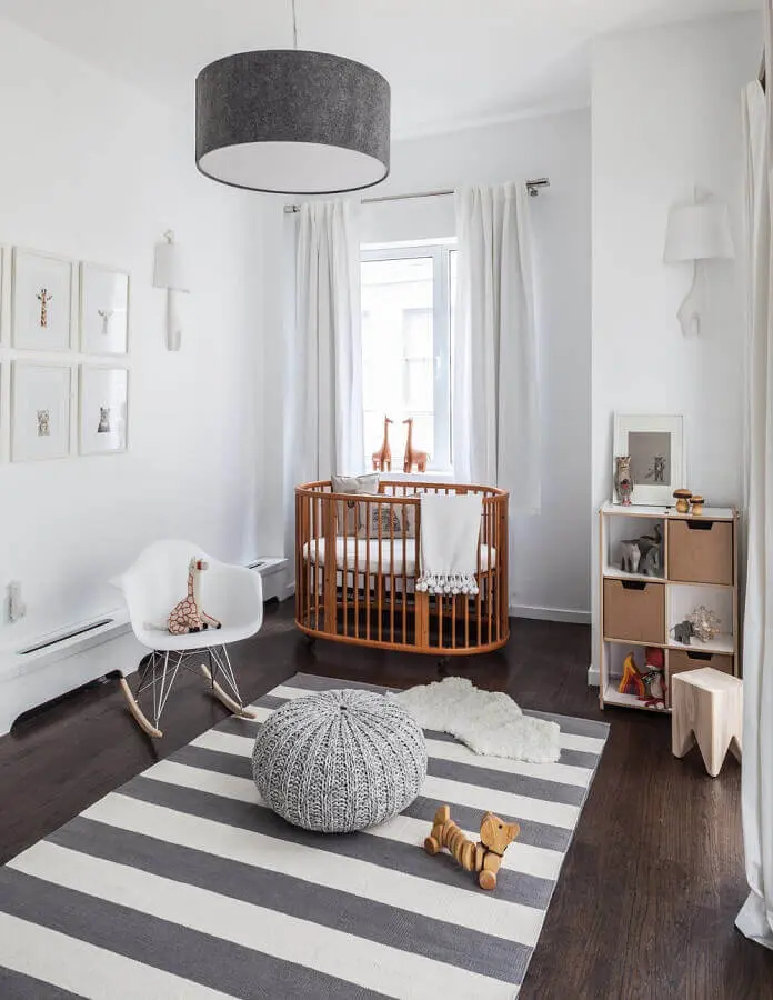 lustre para quarto de bebê decorado em tons de cinza com berço de madeira e tapete listrado Foto Home BNC