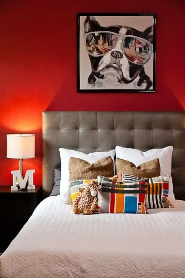 quarto decorado com parede vermelha e cabeceira capitonê cinza Foto Shutterfly