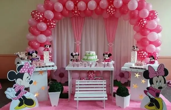 Arco de balões e cortinas nas cores rosa e branco para festa da minnie