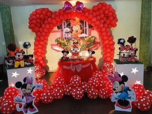 Arco de balões, muitas bexigas e ursinhos de pelúcia na decoração de festa da minnie