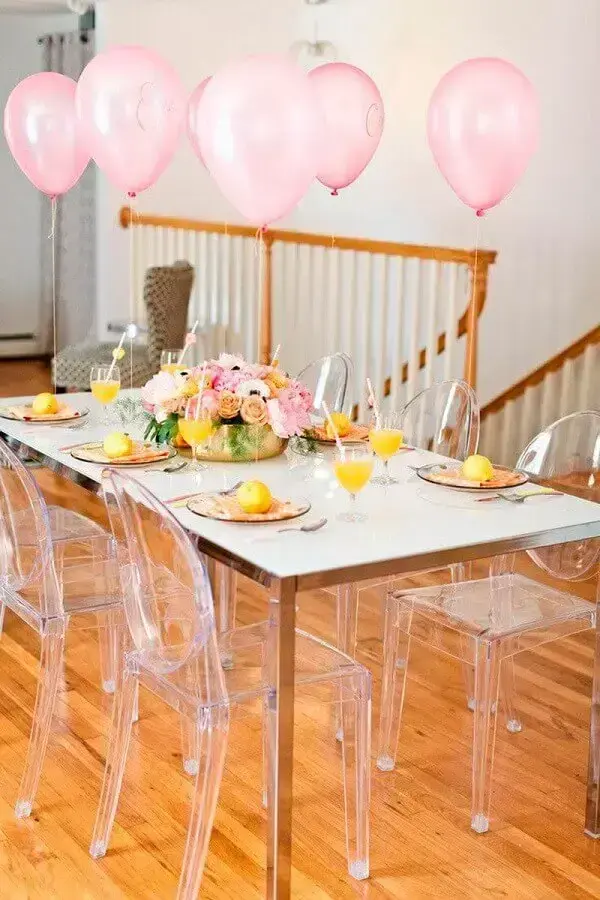 Chá de casa nova com cadeiras transparentes e balões amarelos