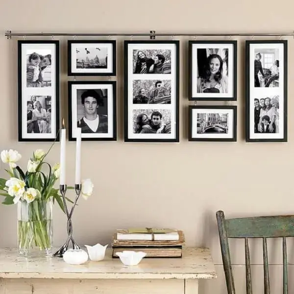 Composição de quadro de fotos pendurados por uma barra metálica