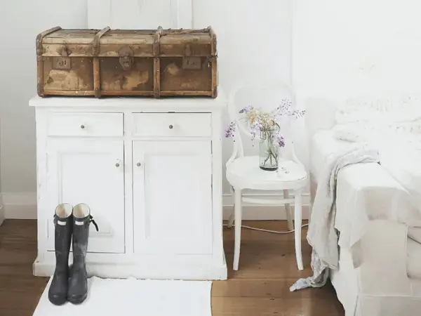 A cômoda branca se harmoniza com a decoração vintage do quarto