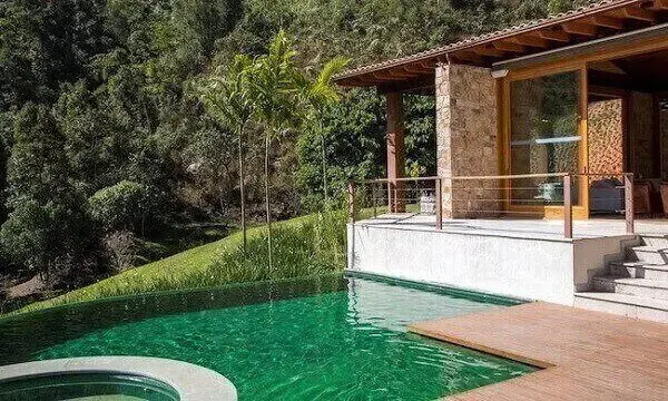 A piscina com borda infinita se mescla com a cor da vegetação