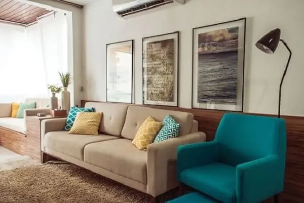 Sala de estar com sofás em tons de bege e poltrona azul turquesa