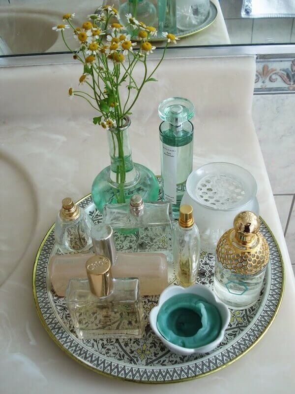 Vidros e frascos vintage utilizados como enfeites para pia de banheiro