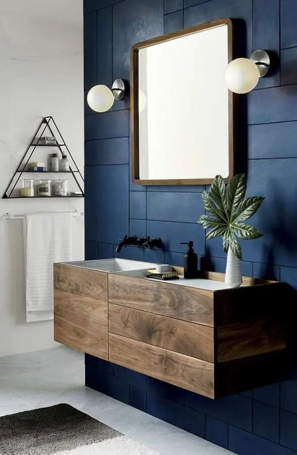 banheiro masculino decorado com revestimento azul escuro e armário de madeira Foto Mauricio Gebara Arquitetura