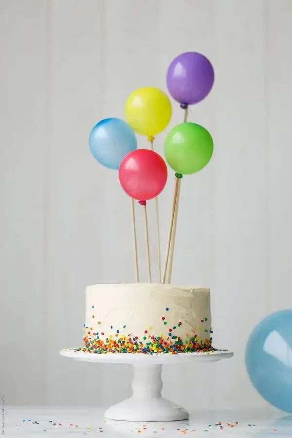 bolo de festa de aniversário simples decorado com granulado colorido e balões no topo Foto SistaCafe