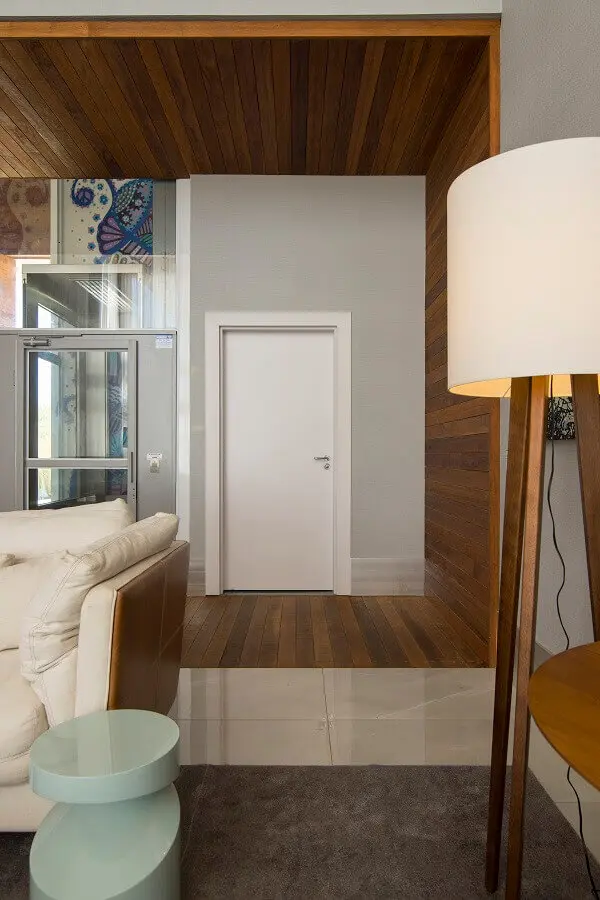 decoração de casa com porta branca e revestimento de madeira