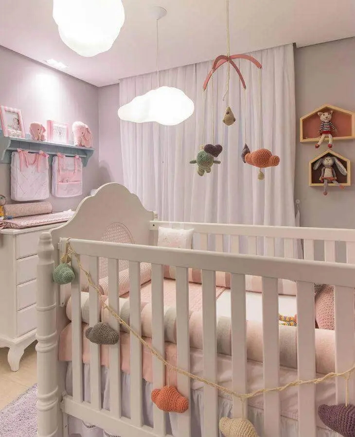 decoração delicada com nichos e prateleiras para quarto de bebê com lustre de nuvem Foto Vamos Mamães