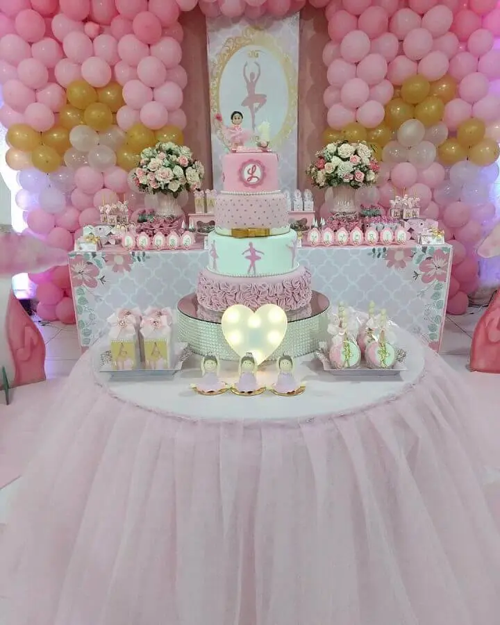 decoração rosa e dourado para festa de bailarina com painel de balões e arranjo de rosas Foto Dream World Festas