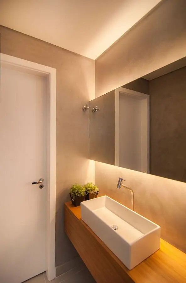 espelho para lavabo com decoração em tons neutros e bancada de madeira Foto Diseno Interior