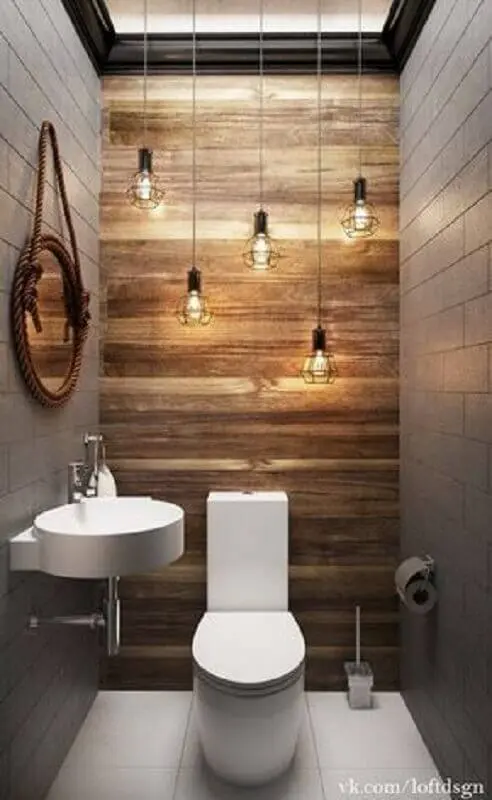 espelho para lavabo pequeno decorado com luminária pendente minimalista e revestimento em madeira para parede Foto Idaho Interior Design