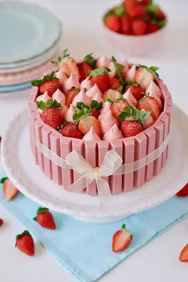 lindo bolo de festa de aniversário decorado com kitkat rosa, suspiros e morangos Foto Flamboesa